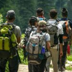 Group of hikers with backpacks walking on a forest trail near Denver, Colorado