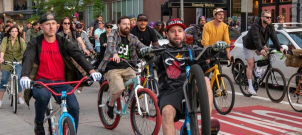 Group of cyclists riding through downtown Denver during a fun community bike event.