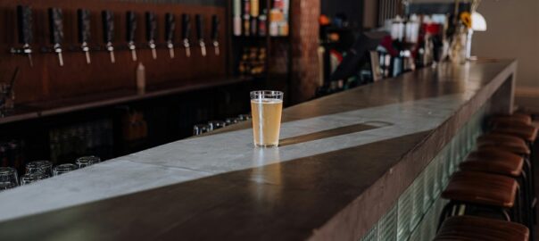 Close-up of hazy IPA on bar amid wooden taps and industrial brewery vibe in RiNo Denver.