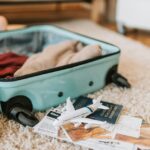 Packed suitcase with passport, toy airplane, and travel essentials for a family trip to Denver.