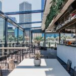 Modern rooftop bar in Denver featuring skyline views, outdoor seating, craft cocktails, and a stylish open-air dining atmosphere.