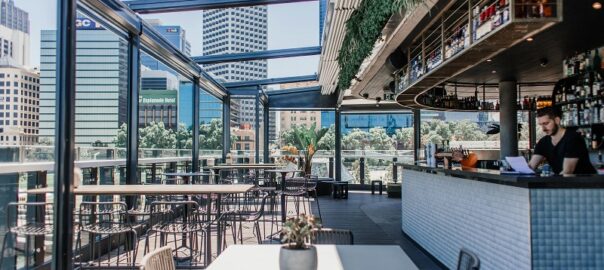 Modern rooftop bar in Denver featuring skyline views, outdoor seating, craft cocktails, and a stylish open-air dining atmosphere.