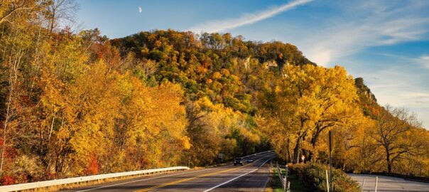 Scenic mountain road near Denver, Colorado, surrounded by colorful trees and autumn foliage during a scenic road trip.