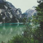 Turquoise alpine lake surrounded by towering mountains and evergreen trees