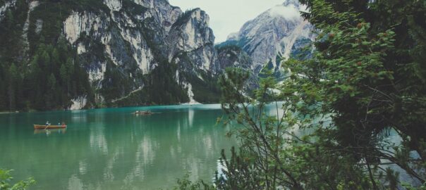 Turquoise alpine lake surrounded by towering mountains and evergreen trees